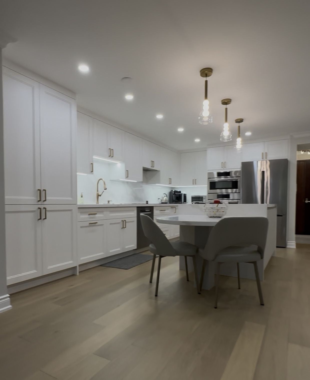 Kitchen renovation — white shaker cabinetry, island seating, hardwood floor