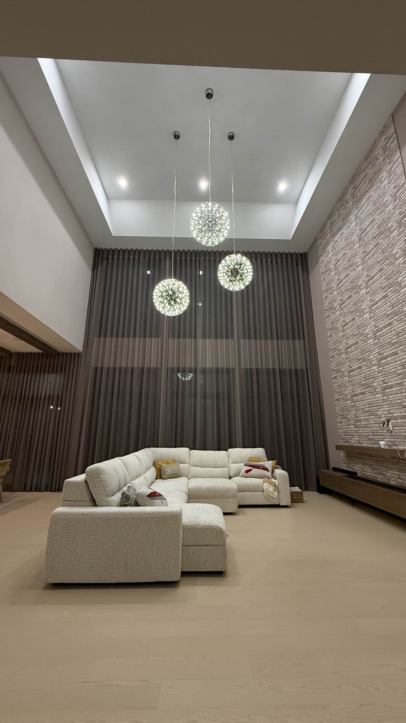 Interior finishing — double-height living room, coffered ceiling, crystal chandeliers at night