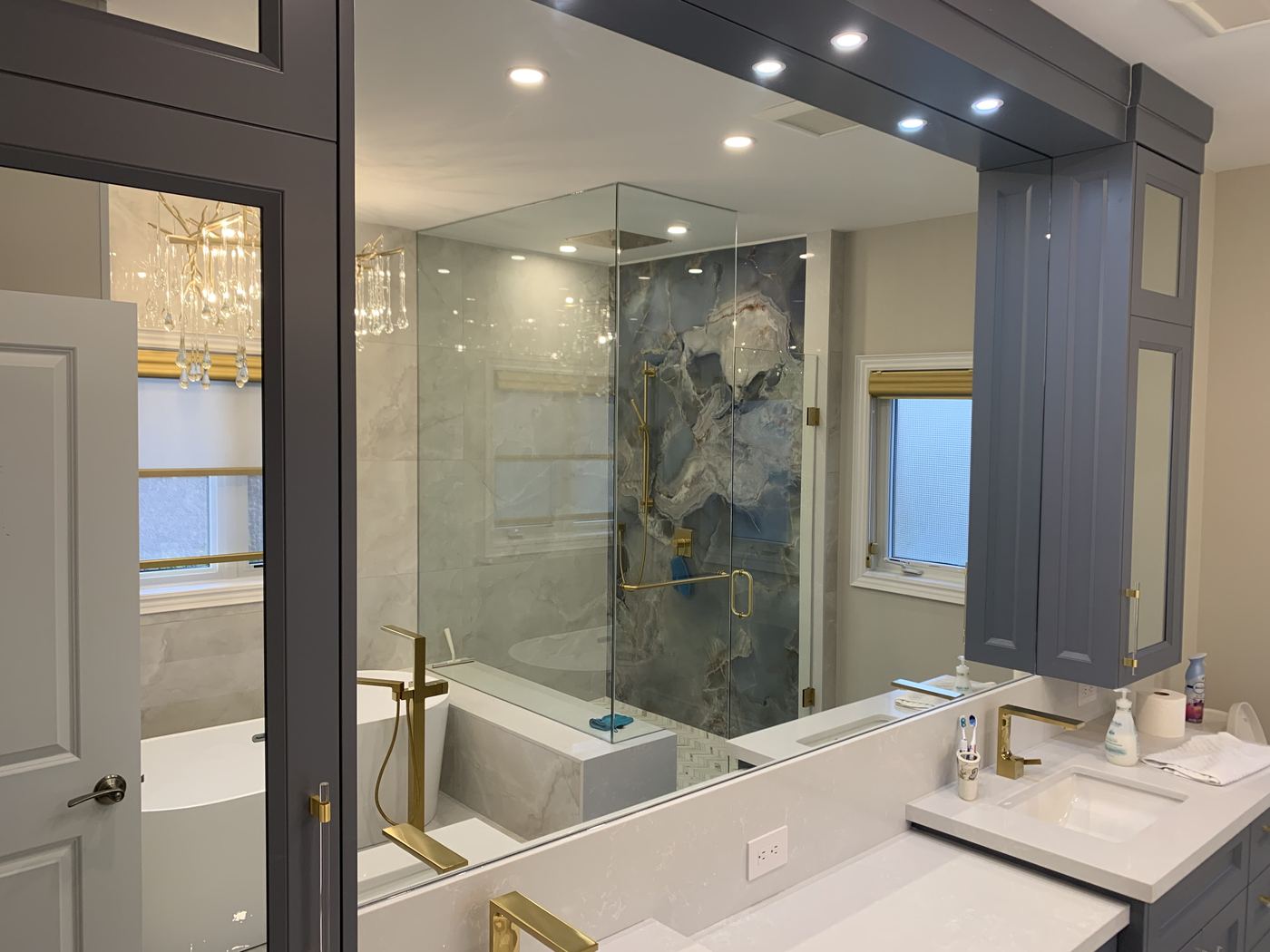 Bathroom renovation — grey shaker vanity, blue marble shower, freestanding tub