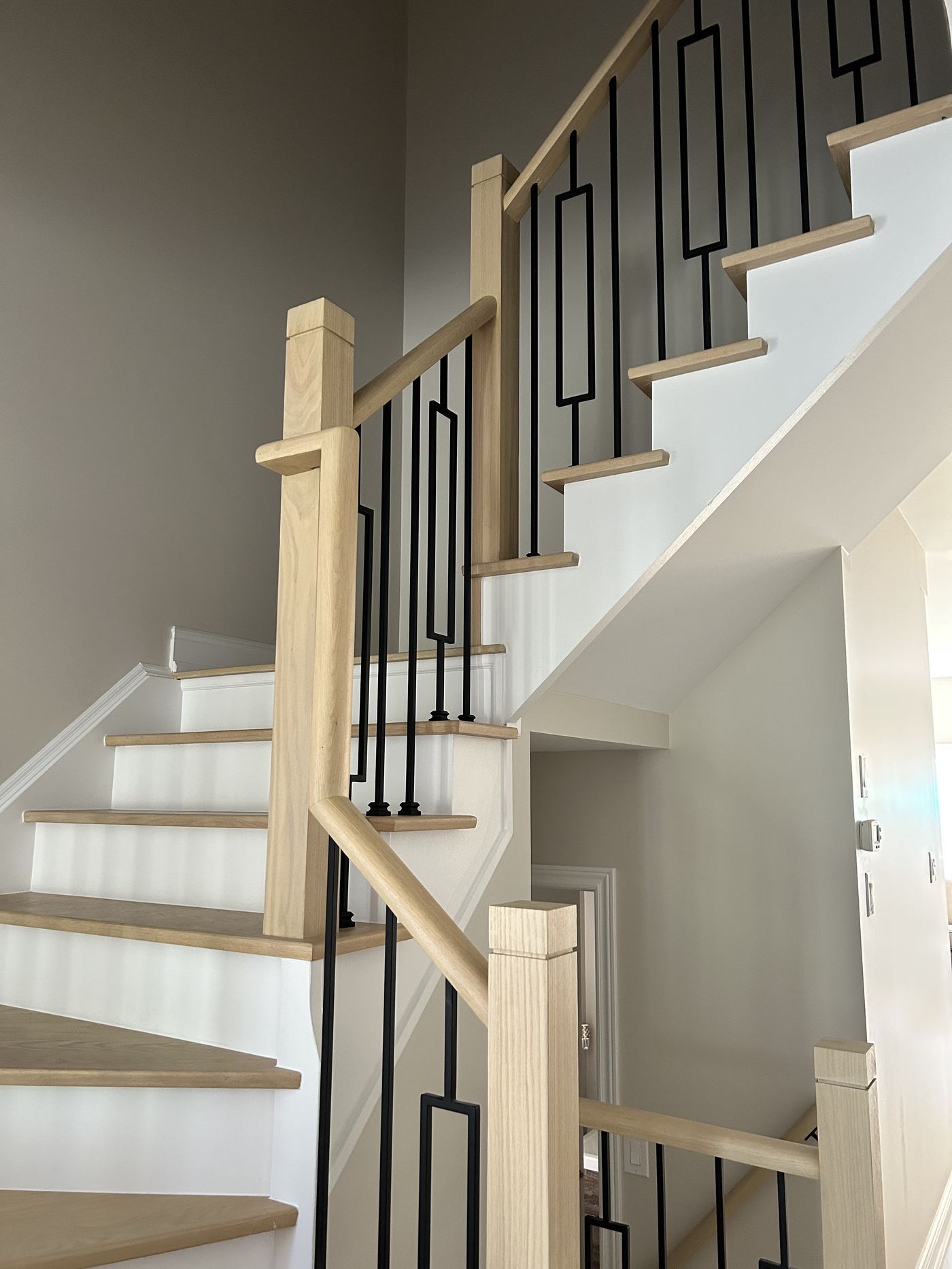 Interior finishing — custom white oak staircase with black iron balusters