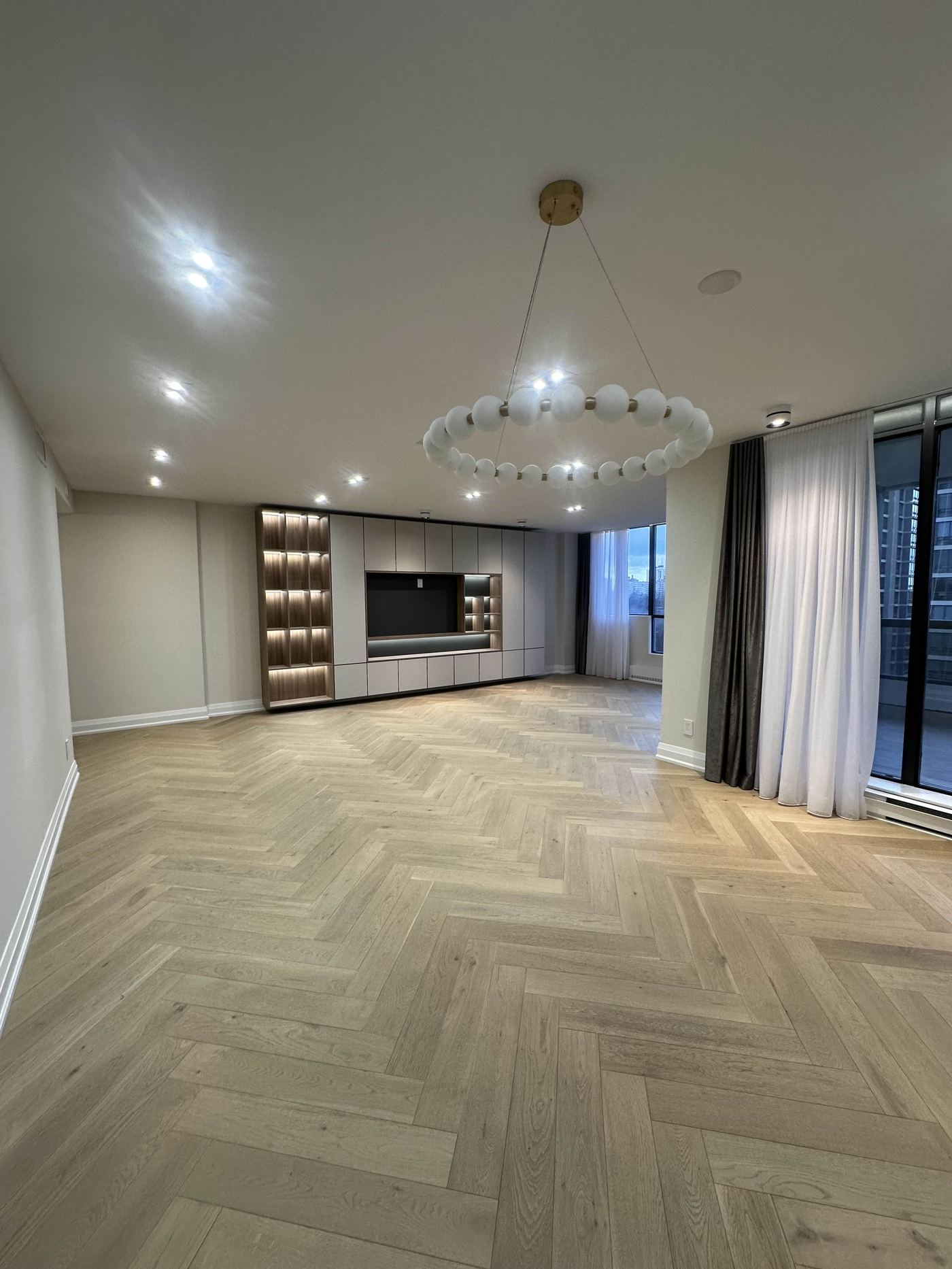 Interior renovation — herringbone hardwood living room with built-in media wall