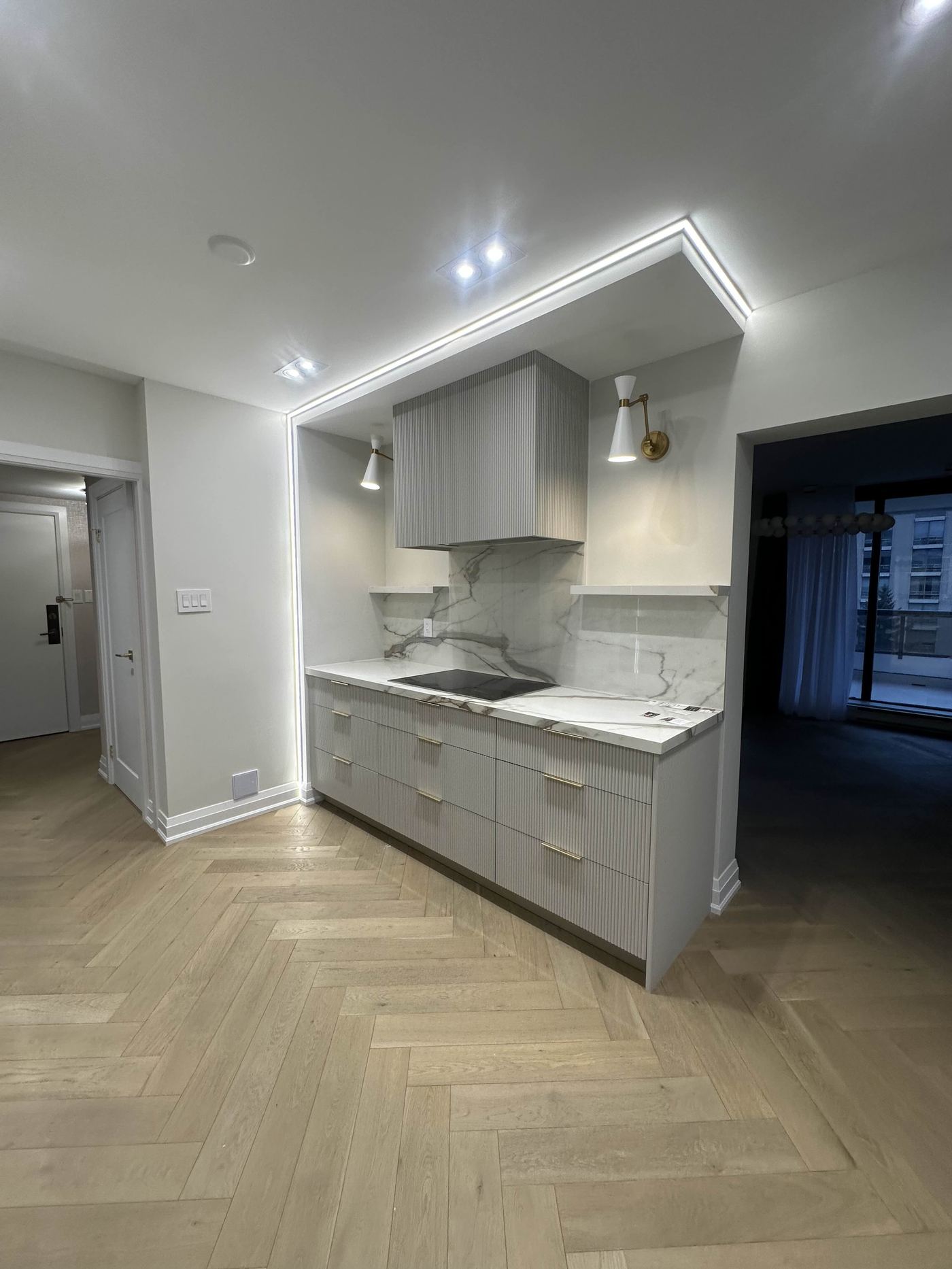 Kitchen renovation — ribbed grey cabinets, marble backsplash, herringbone floor
