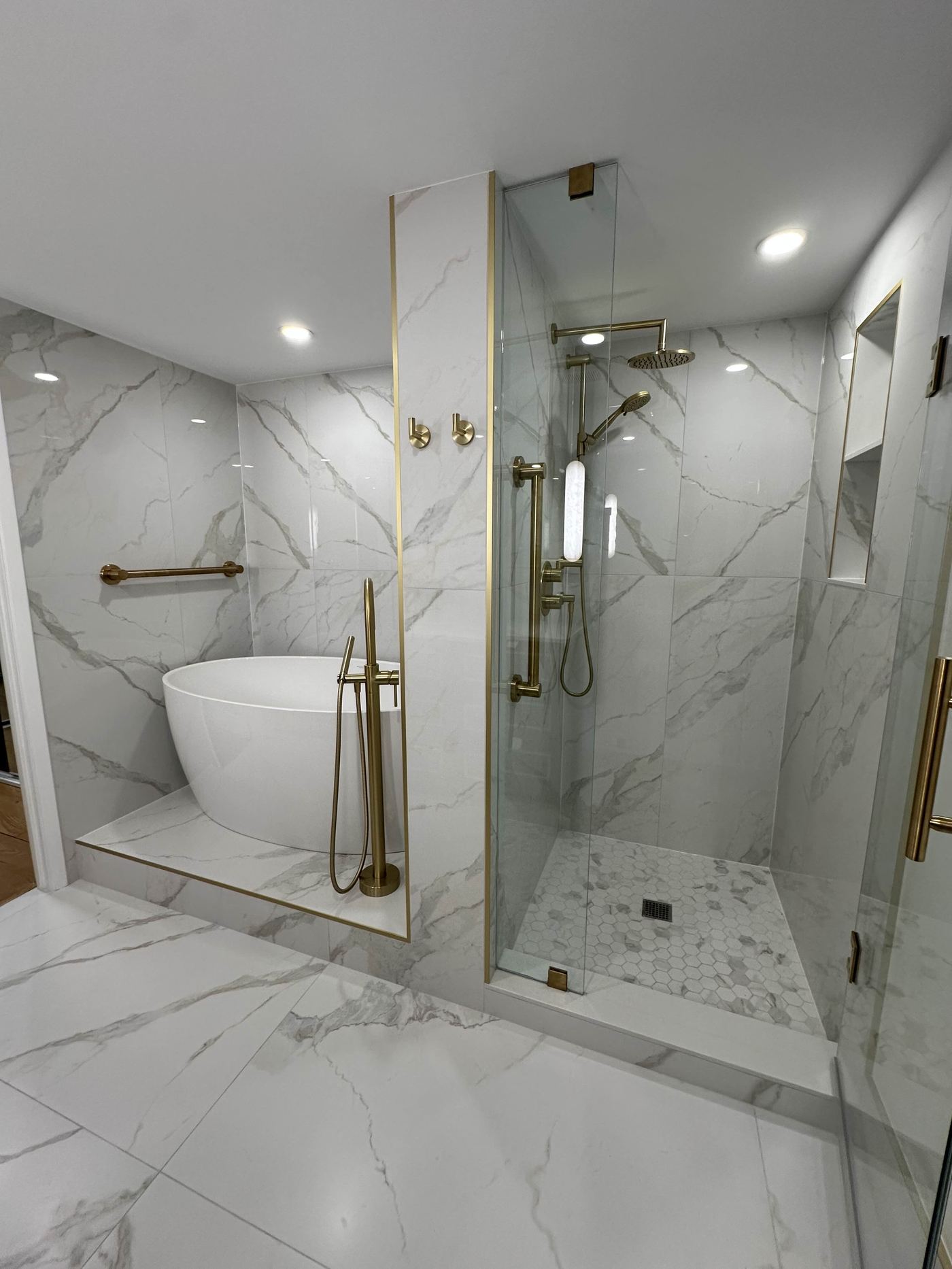 Bathroom renovation — freestanding soaker tub, walk-in shower, all marble and gold